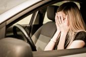 Young woman with hands on eyes sitting depressed in car 71965996